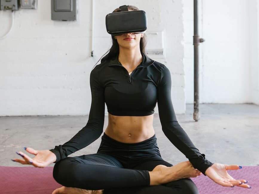 woman doing yoga while wearing virtual reality glasses